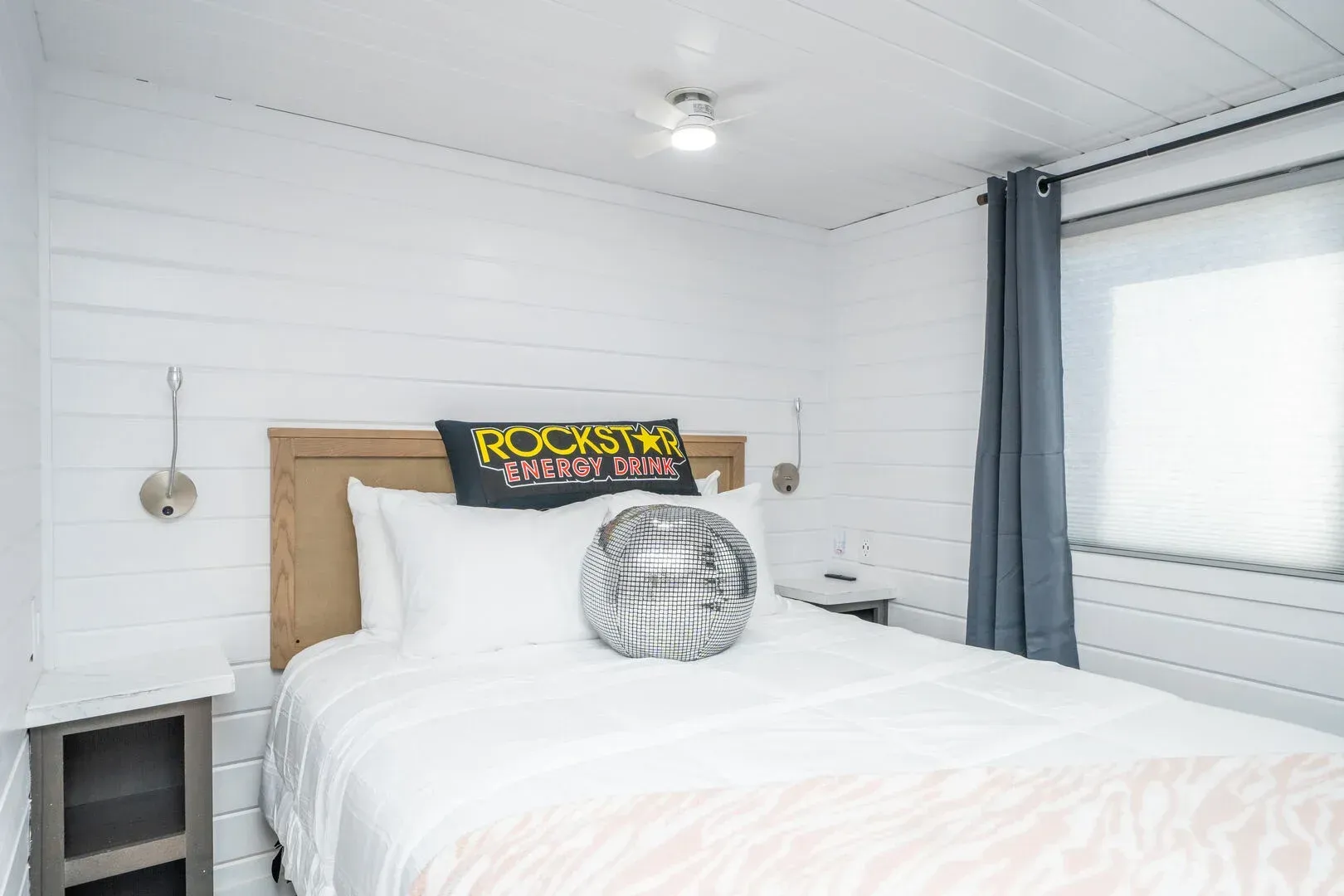 A bedroom with a bed , nightstand , and window.