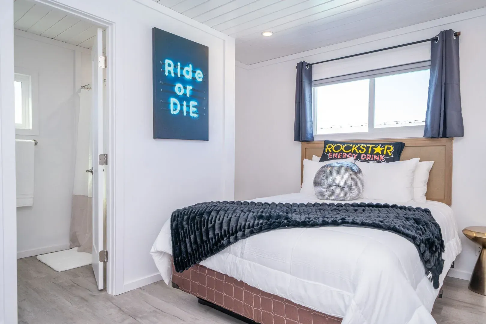 A bedroom with a bed and a sign on the wall that says ride or die