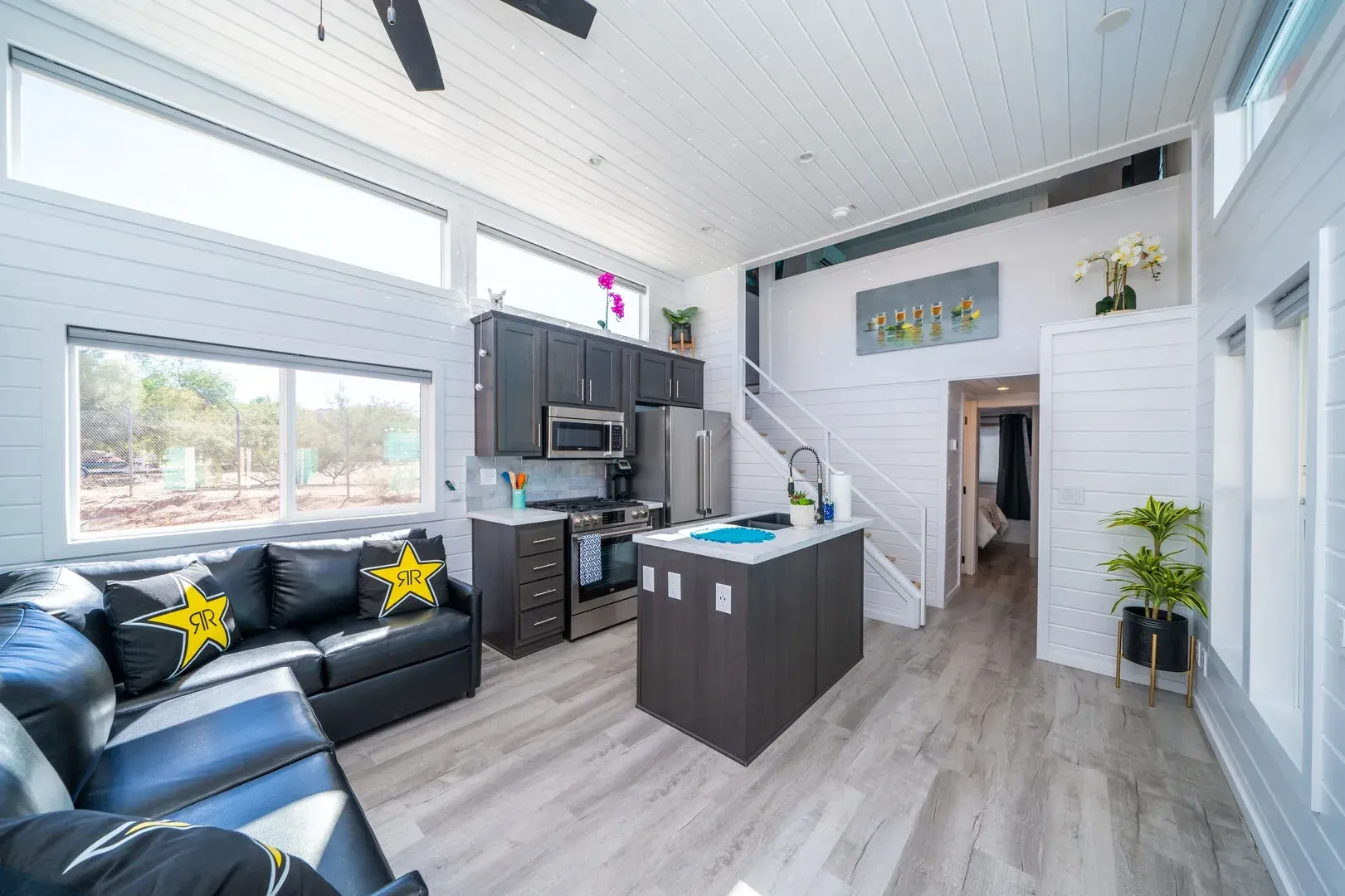 A living room with a couch and a kitchen in a small house.