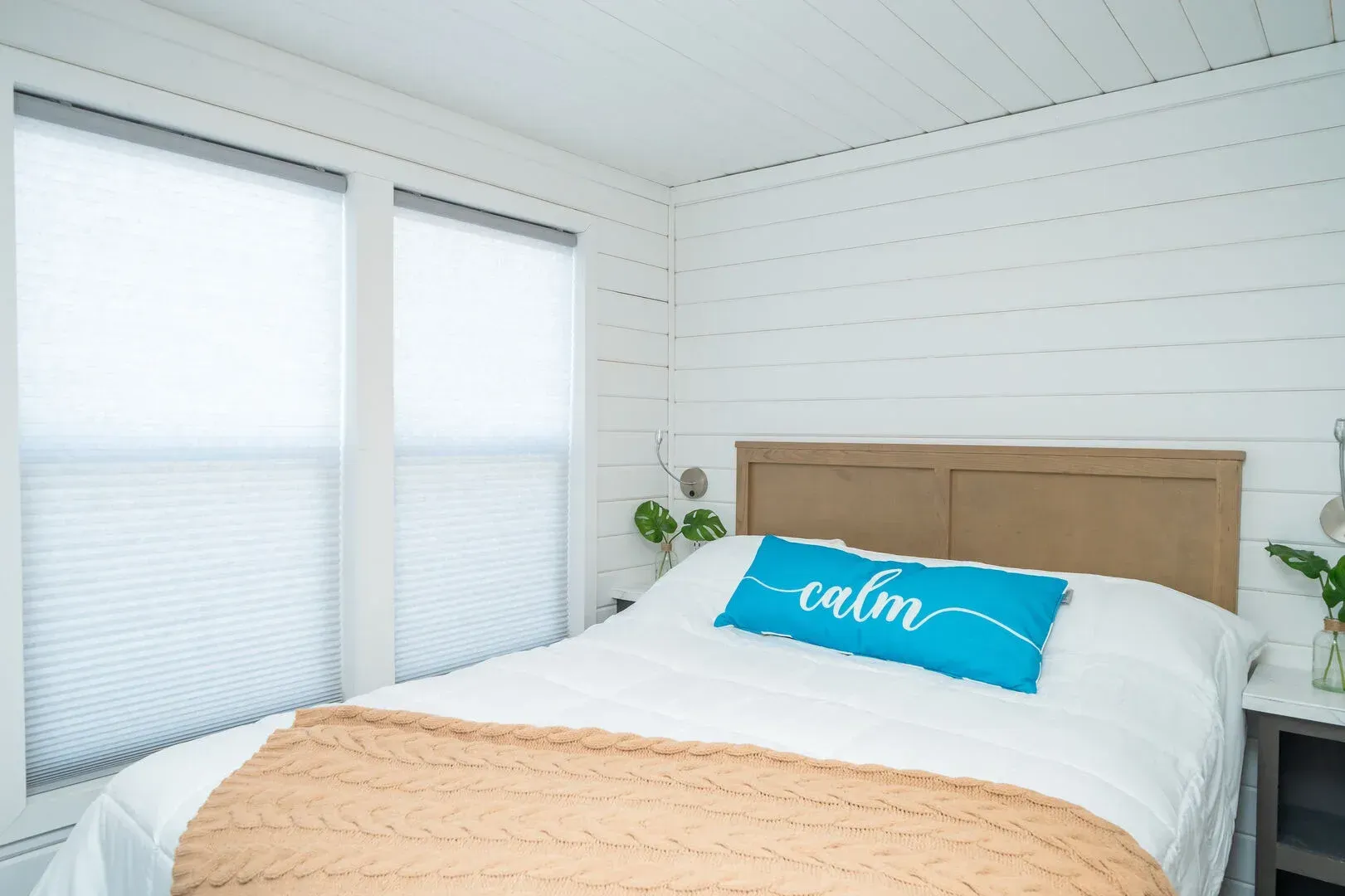 A bed with a blue pillow that says calm on it.