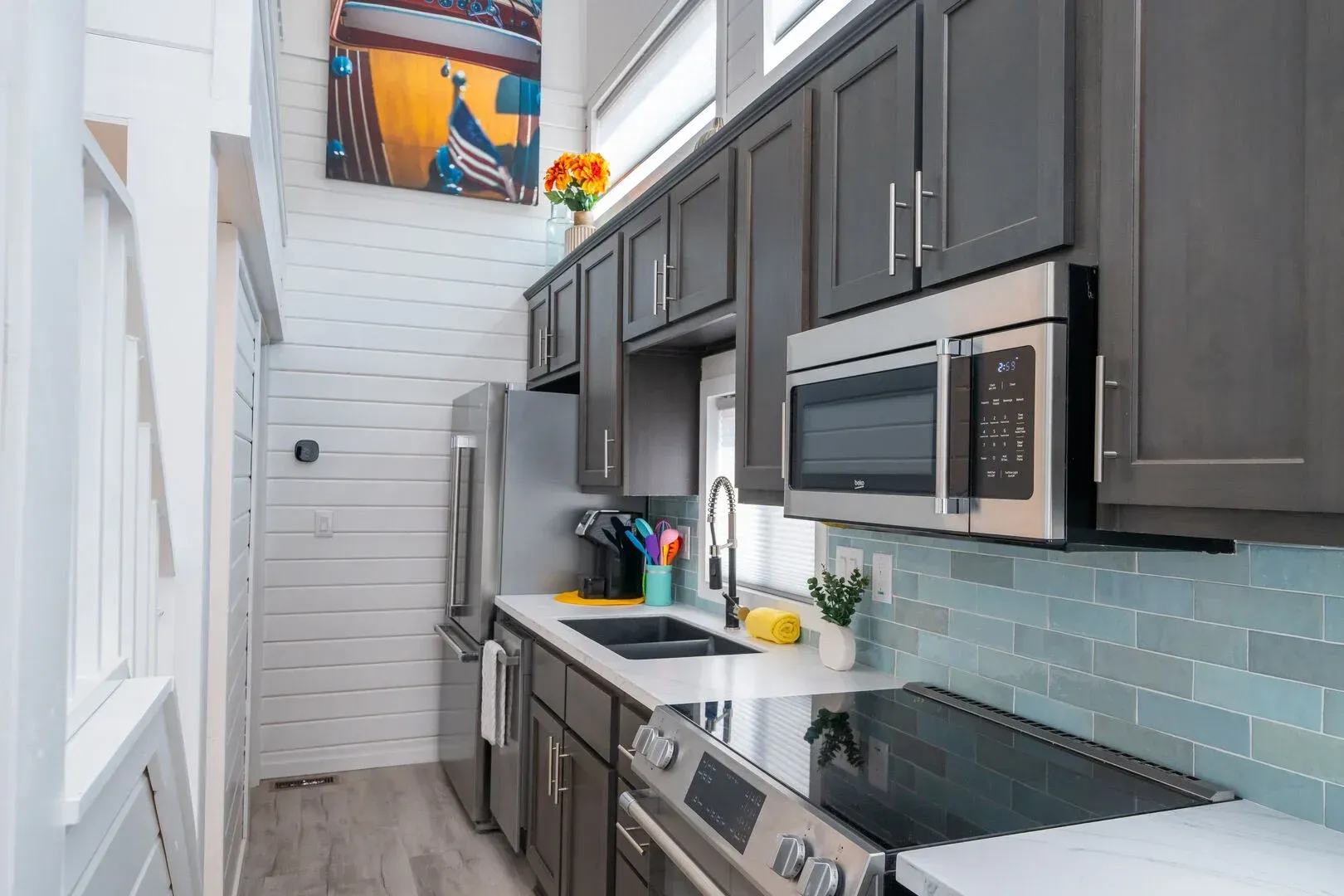 A kitchen with stainless steel appliances and gray cabinets.