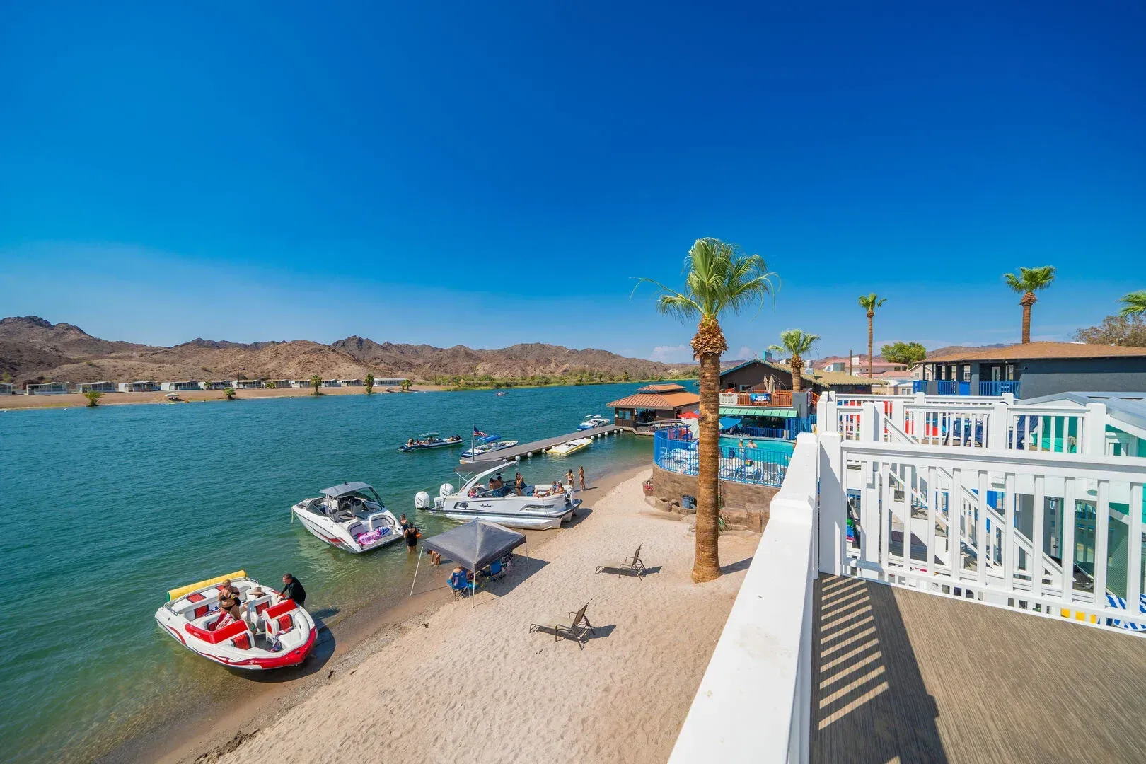 A group of boats are docked on the shore of a lake.
