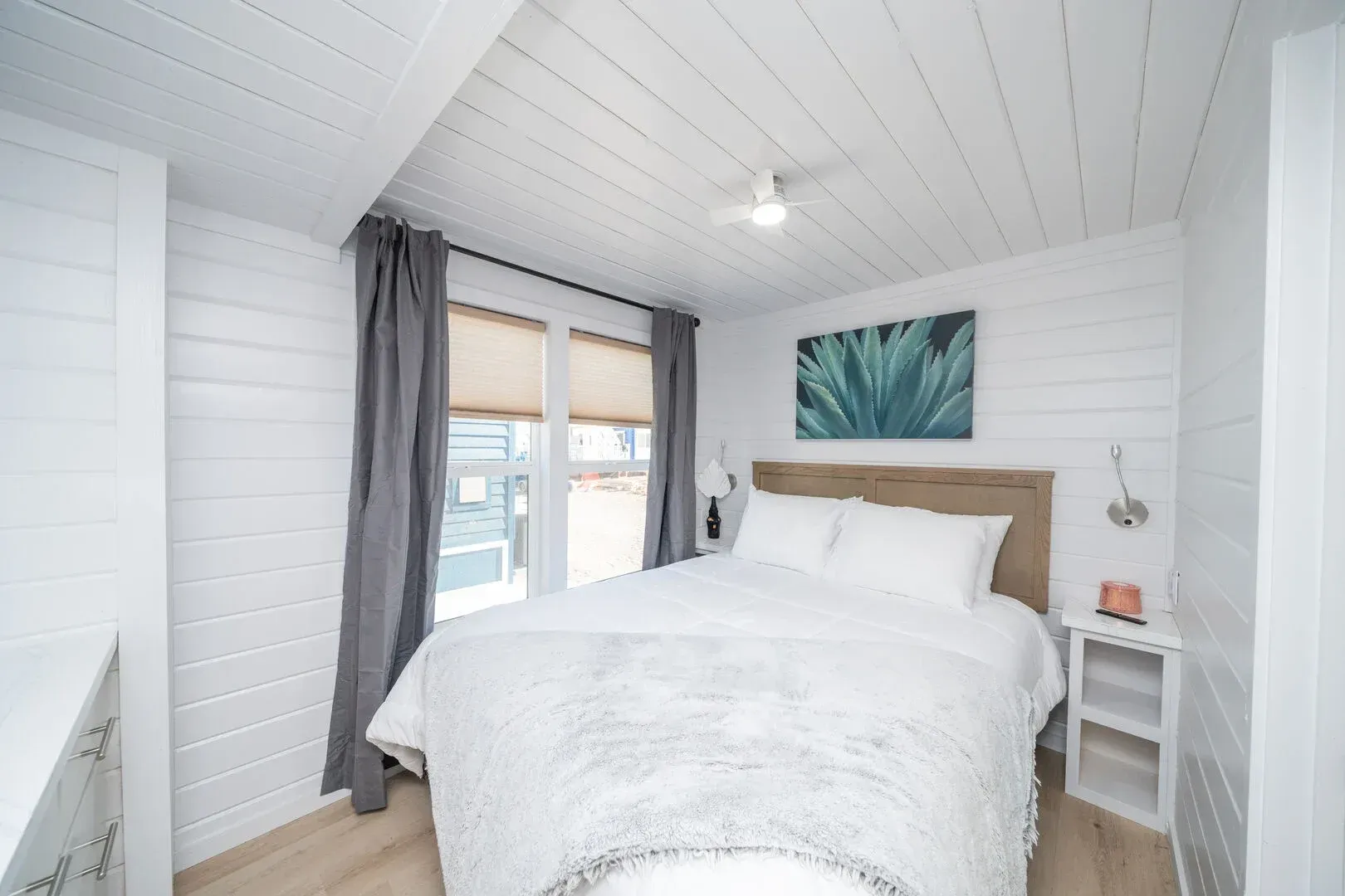 A bedroom with a king size bed and a painting on the wall.