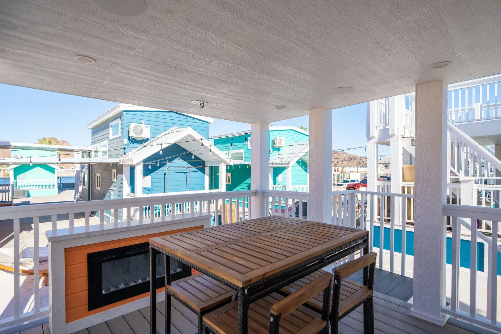 There is a table and chairs on the porch of a house.