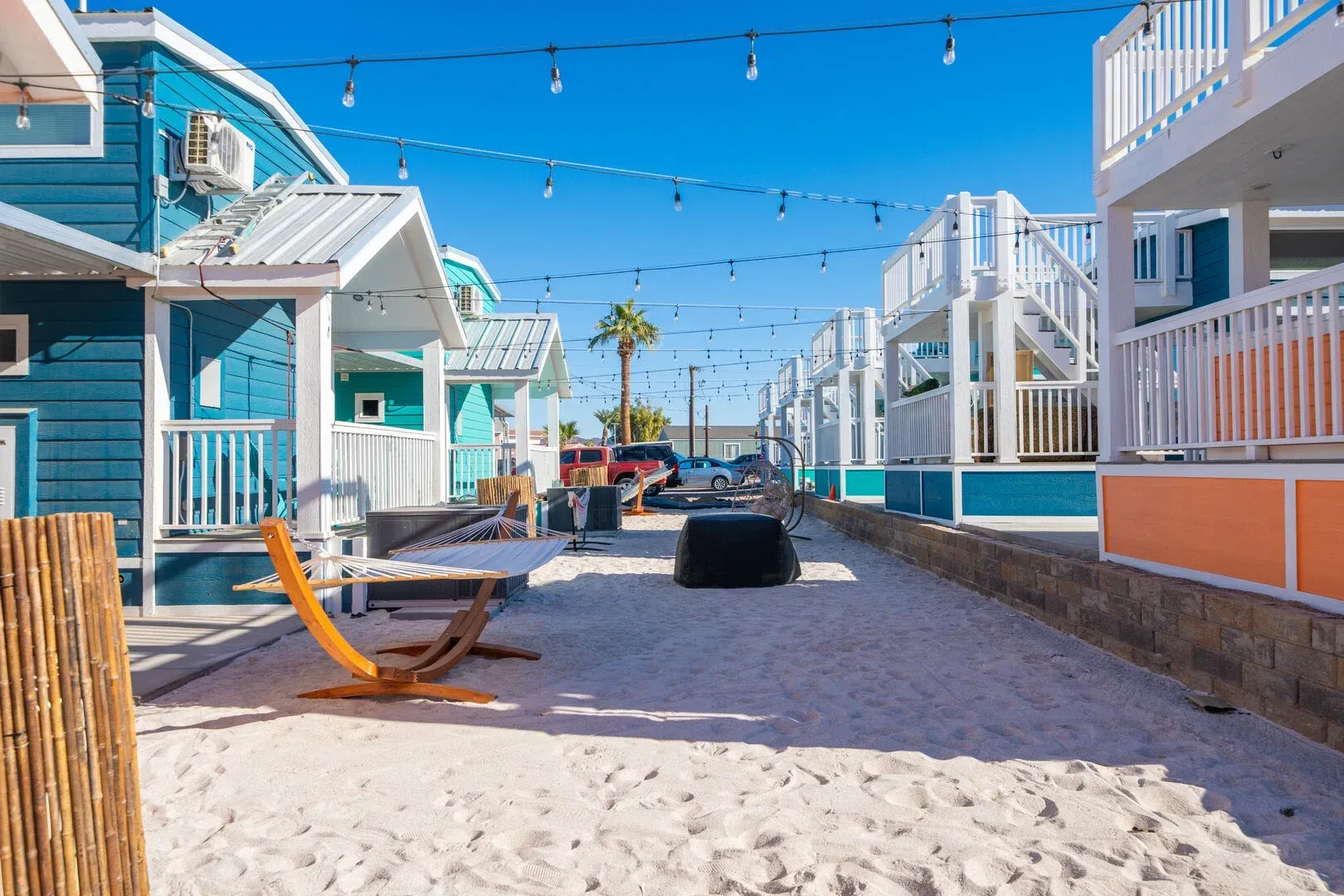 A row of houses sitting next to each other on a sandy beach.