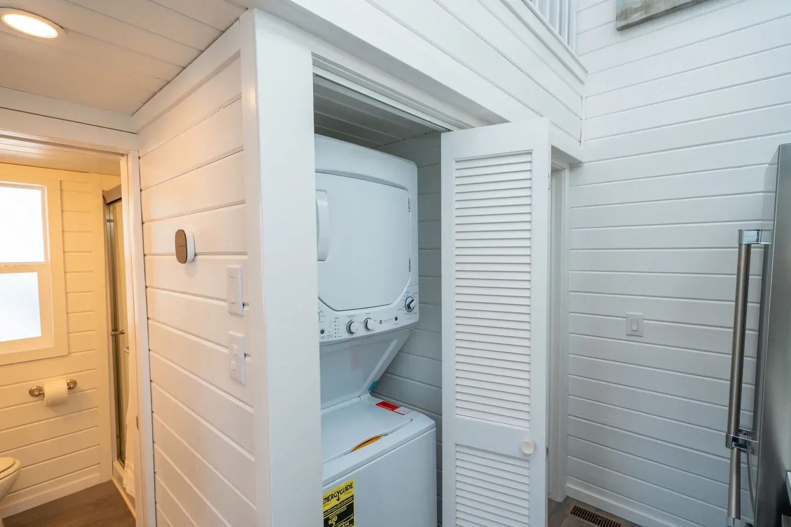 A washer and dryer are stacked on top of each other in a closet.