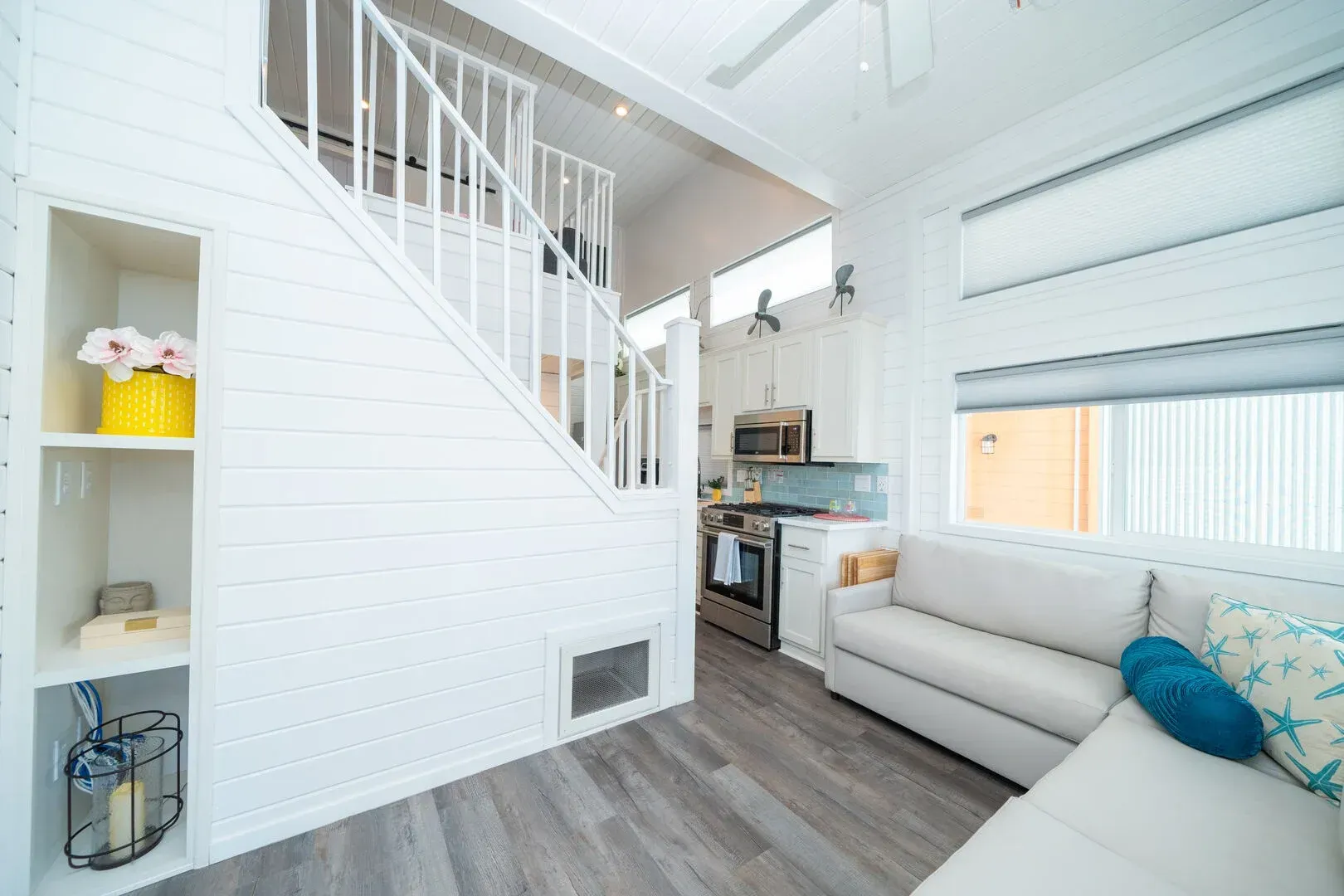 A living room with a couch and stairs leading up to the second floor.