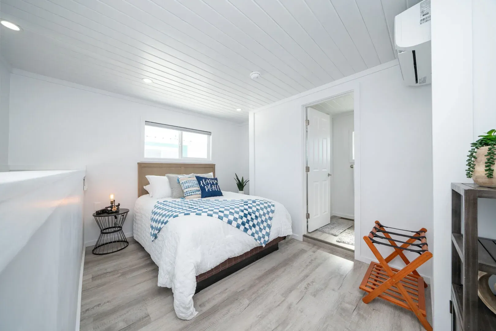 A bedroom with a king size bed and a wooden floor.