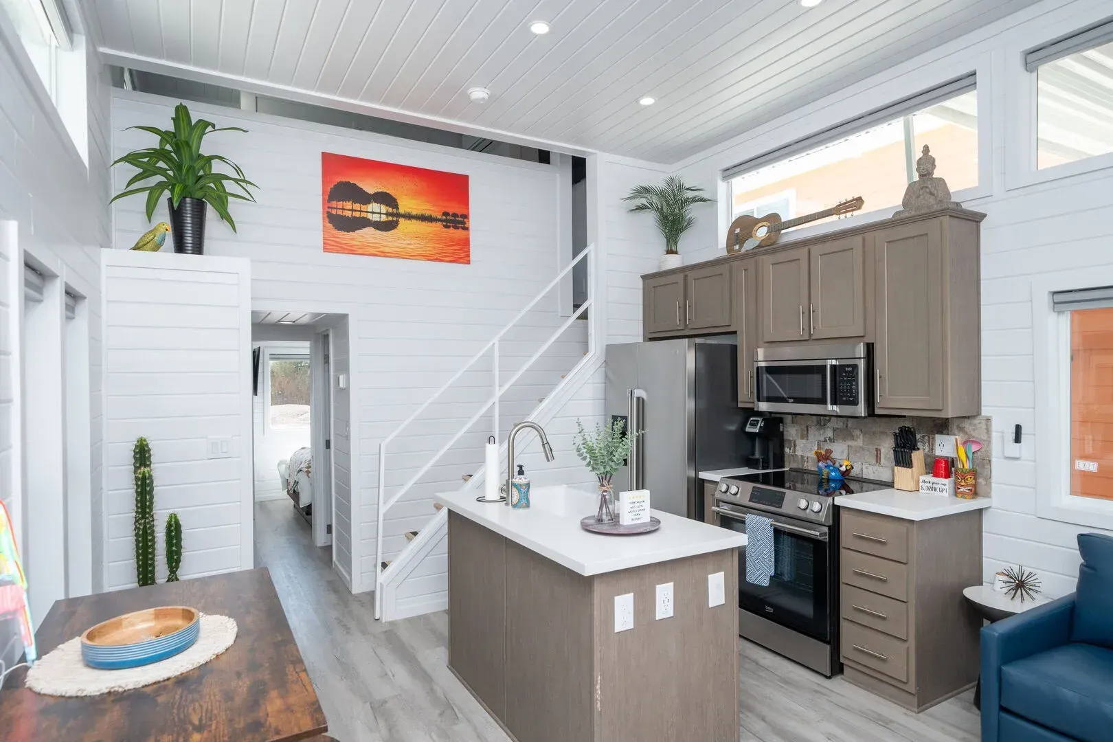A kitchen with a large island and a staircase leading up to the second floor.