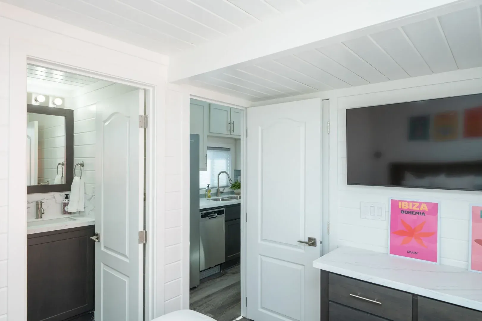 A bedroom with a large flat screen tv on the wall.