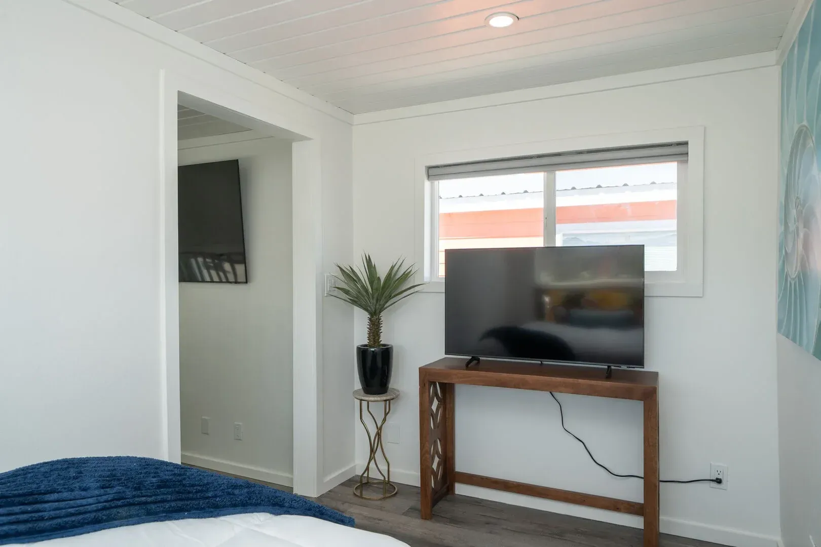 A bedroom with a bed and a television on a table.