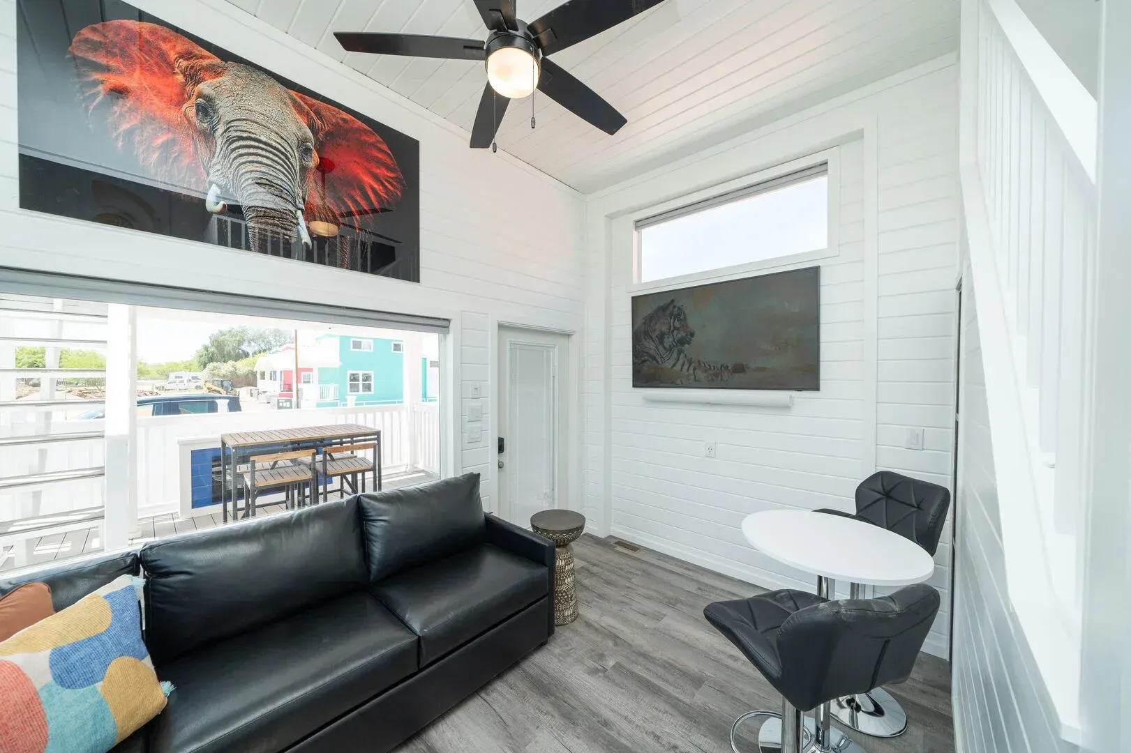 A living room with a couch , table and chairs and a ceiling fan.