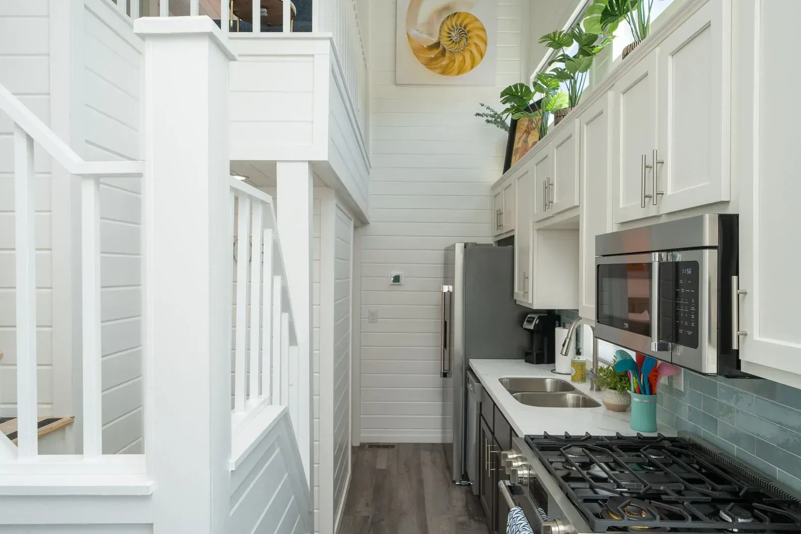 A kitchen with a stove , sink , refrigerator and microwave.