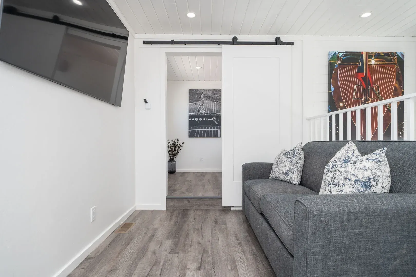 A living room with a couch and a television on the wall.