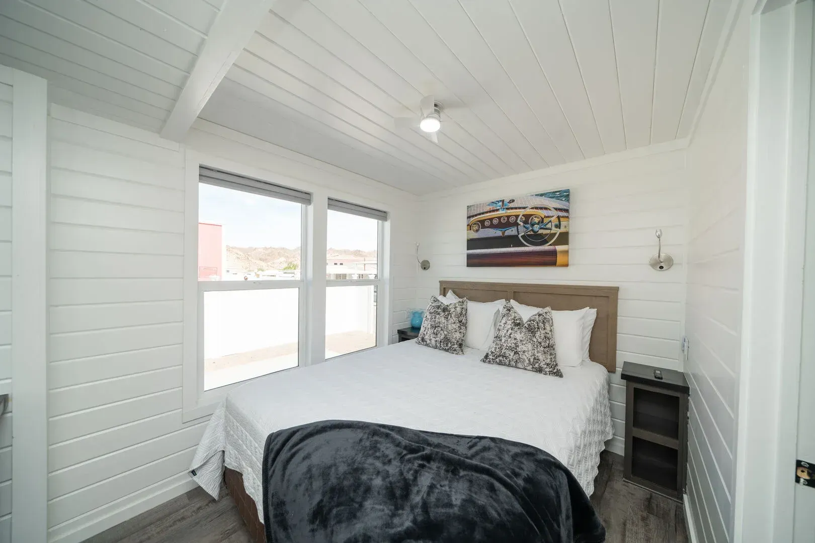 A bedroom with a king size bed and two windows.
