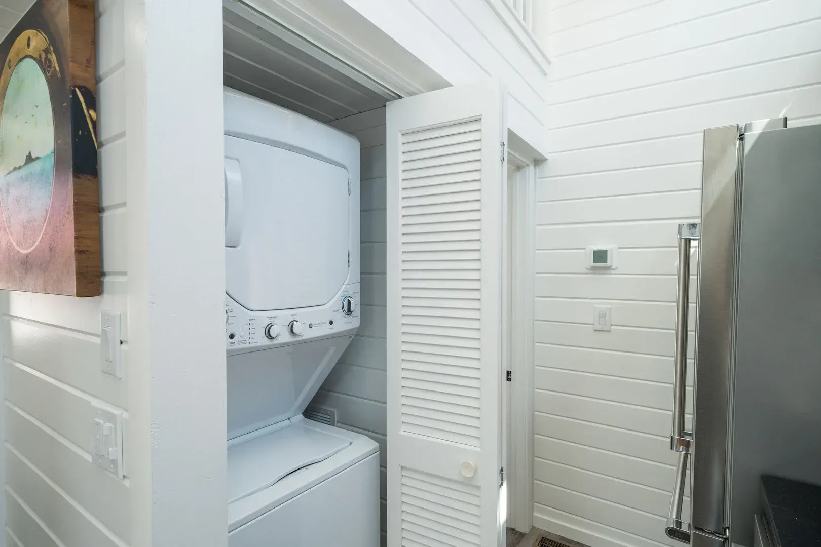 A washer and dryer are stacked on top of each other in a laundry room.