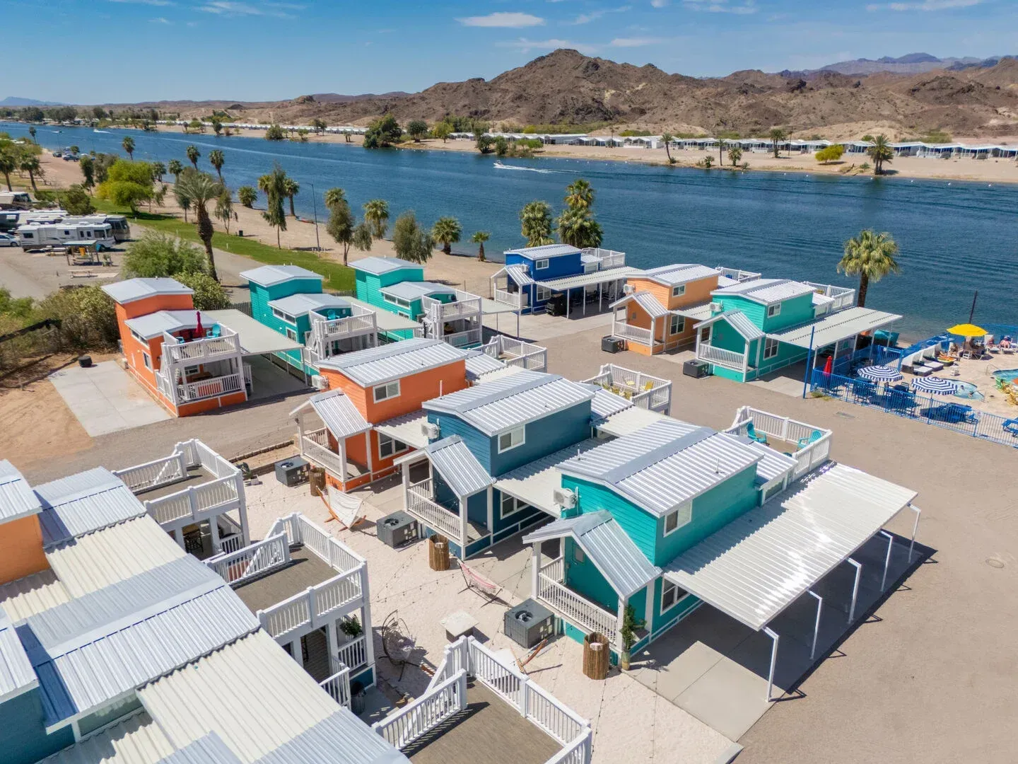 An aerial view of a row of colorful houses next to a river.