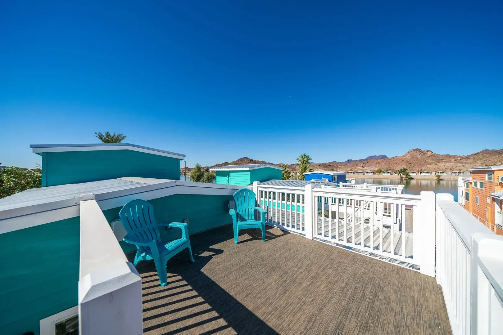There are two chairs on the balcony of a house.