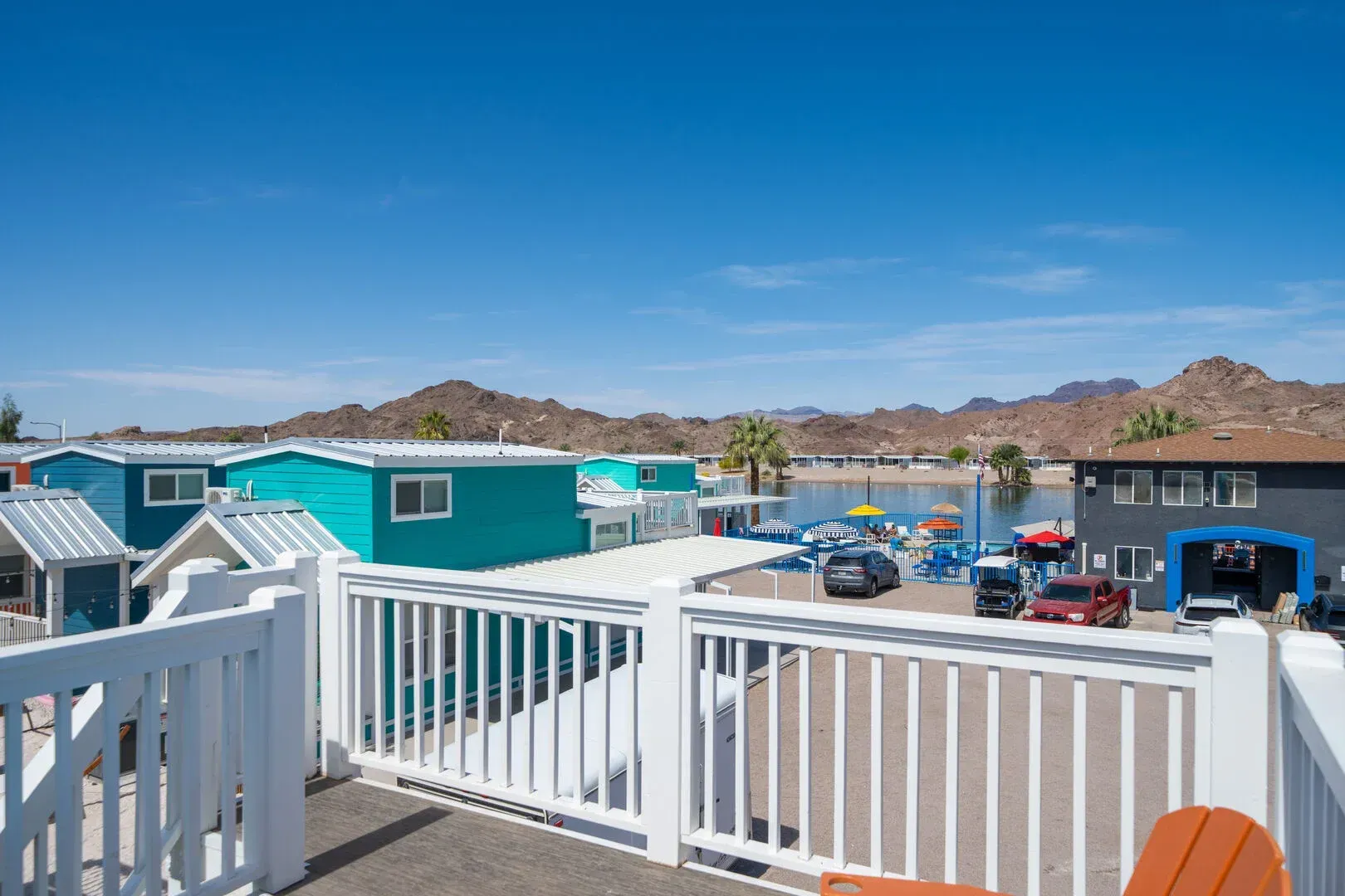 There is a balcony with a view of a lake and buildings.