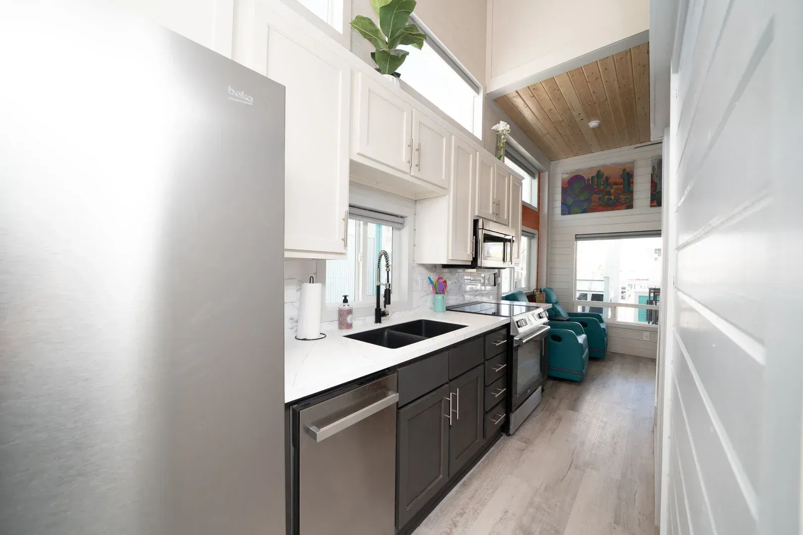 A kitchen with stainless steel appliances and white cabinets.