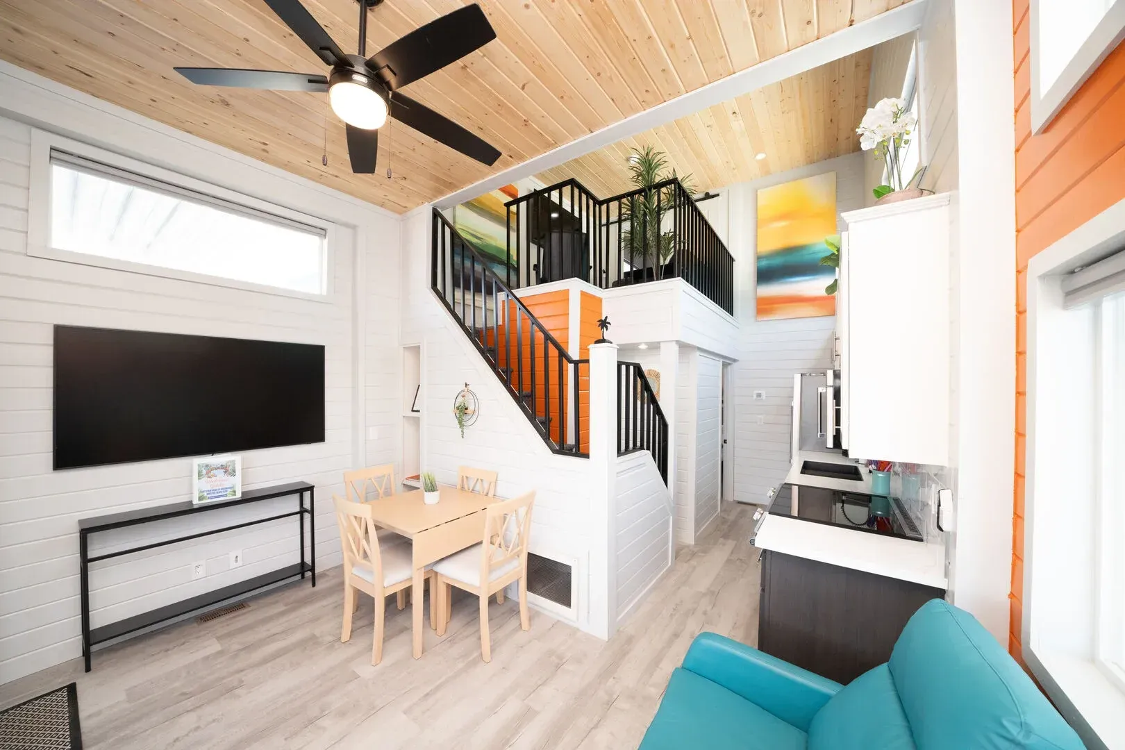 A living room with a blue chair and a ceiling fan.