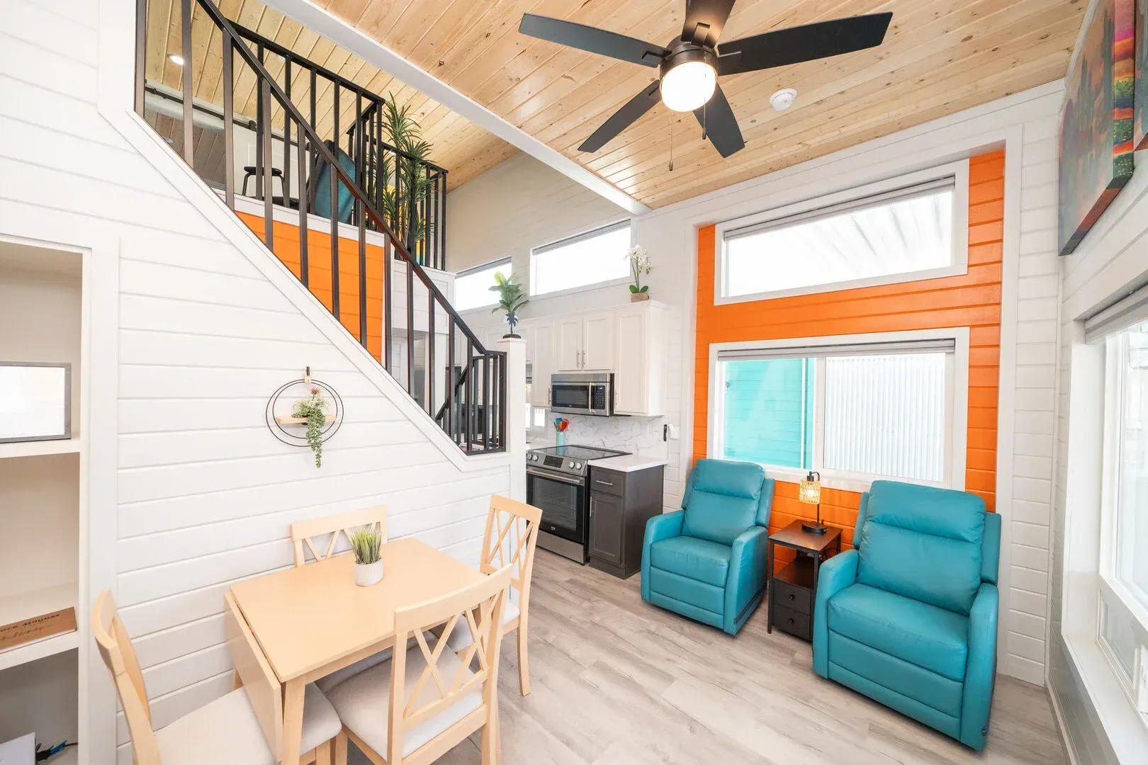 A living room with a table and chairs and a ceiling fan.