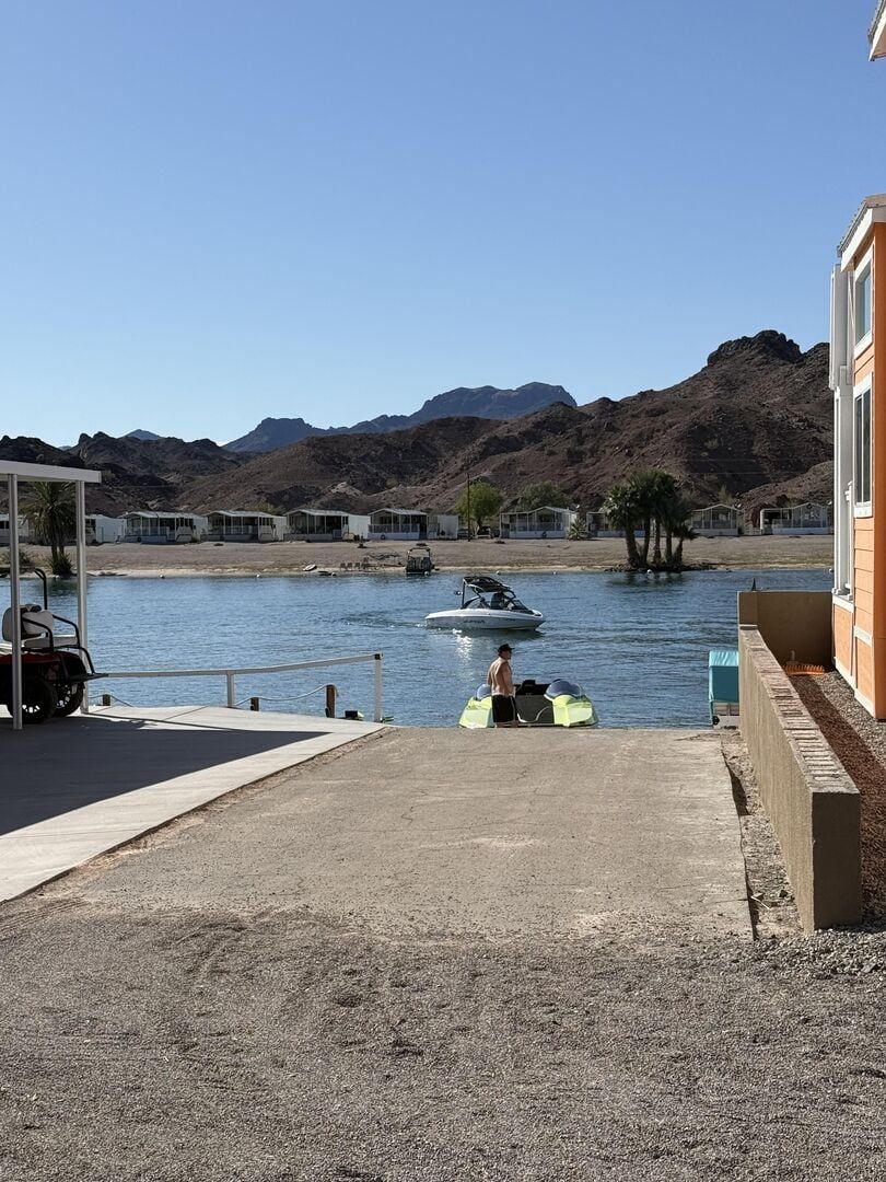 A man is riding a jet ski on a lake next to a house.