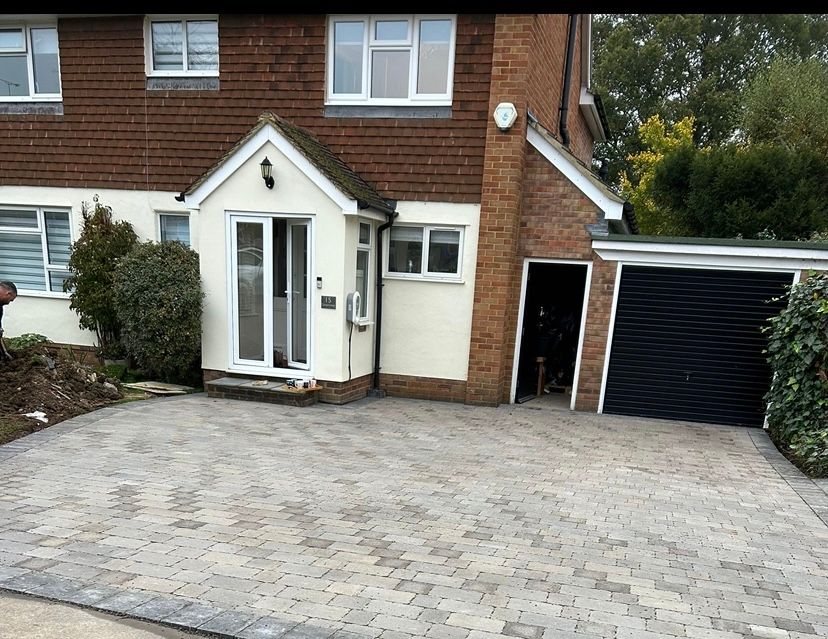 A house with a garage and a driveway in front of it.
