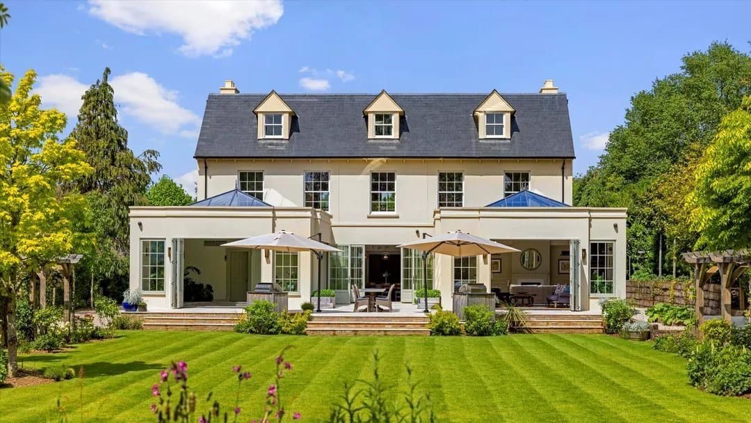 A large white house with a large lawn in front of it.