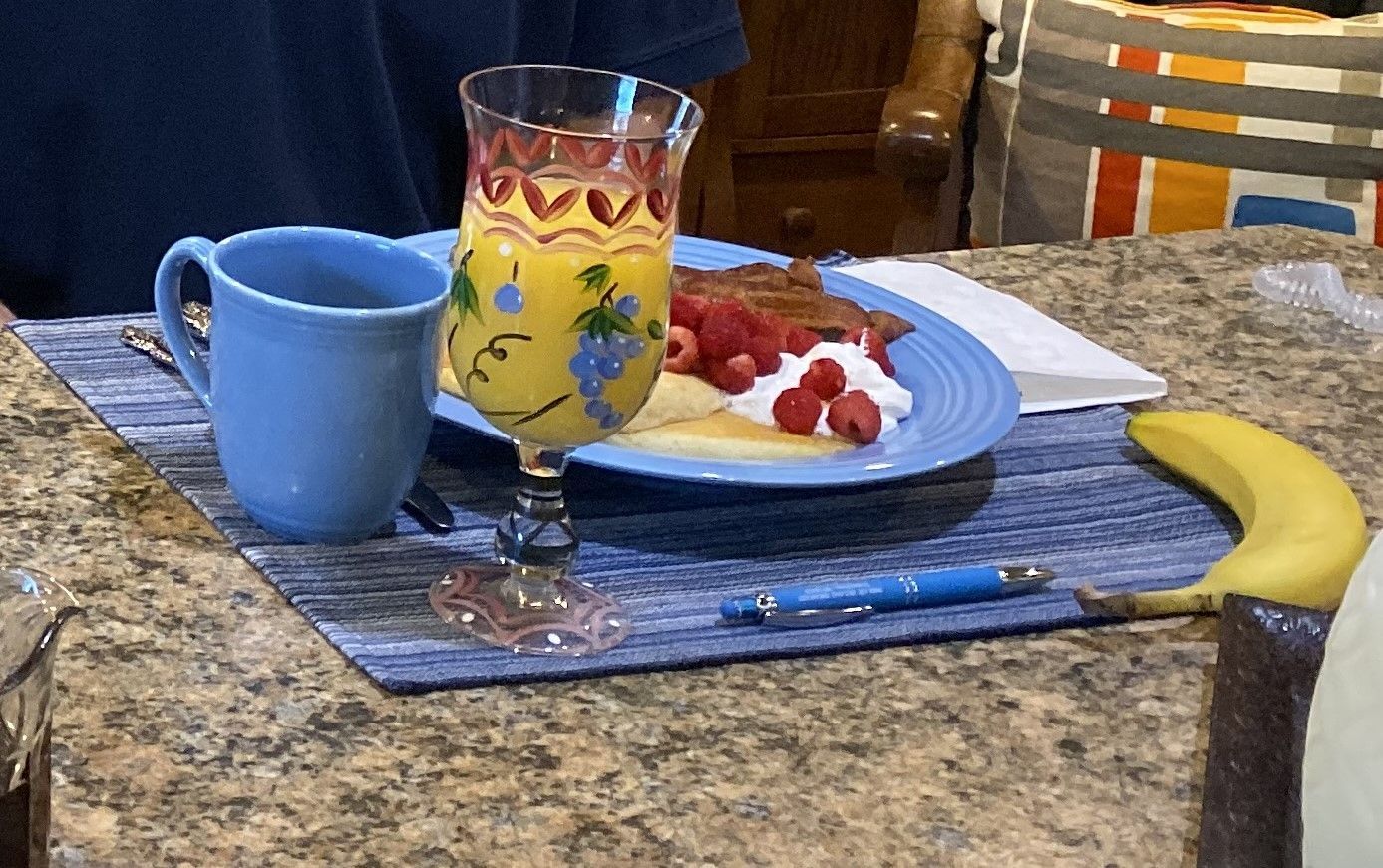 A plate of french toast with bananas strawberries and blueberries