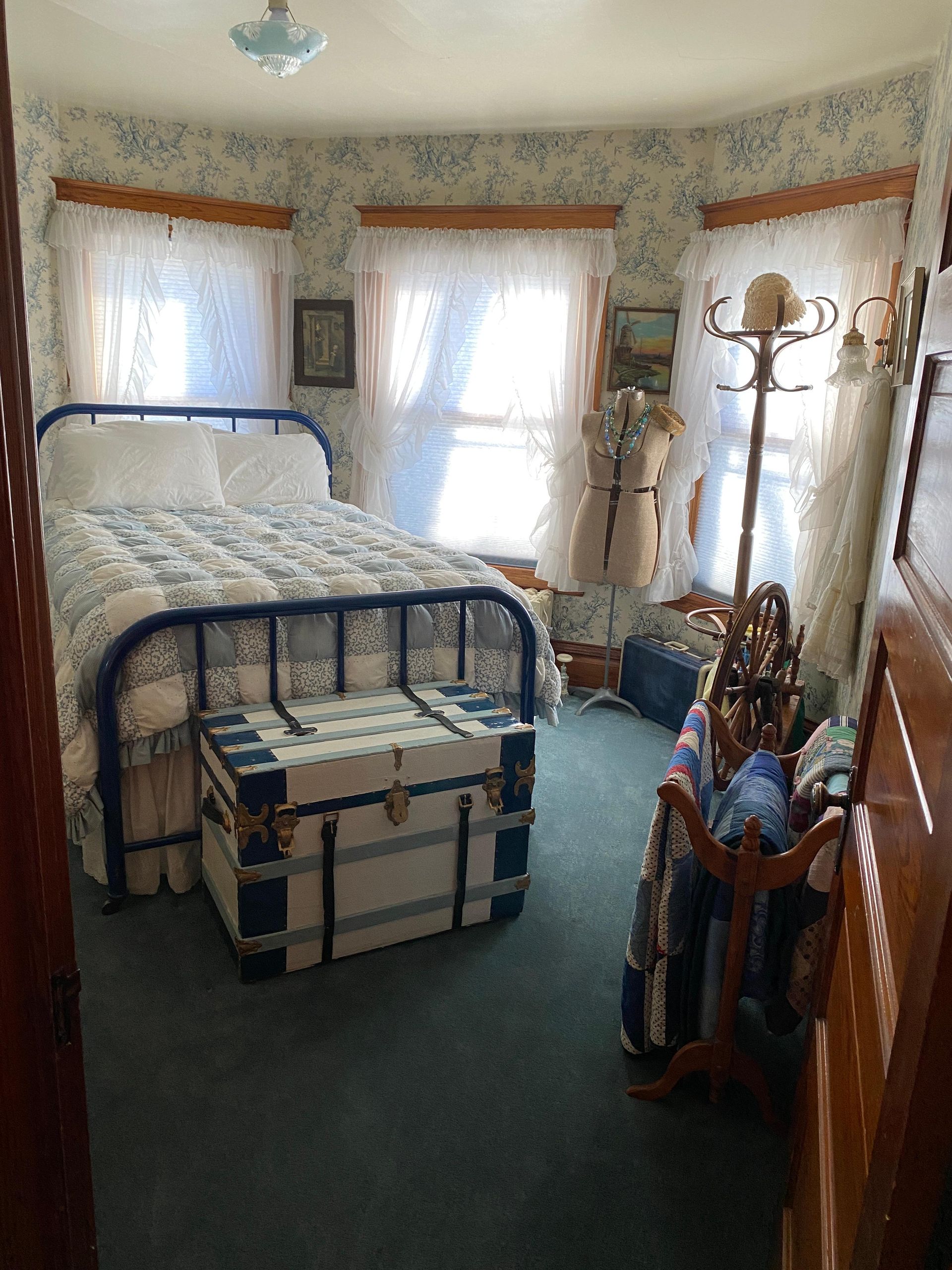 A bedroom with a bed and a trunk on the floor