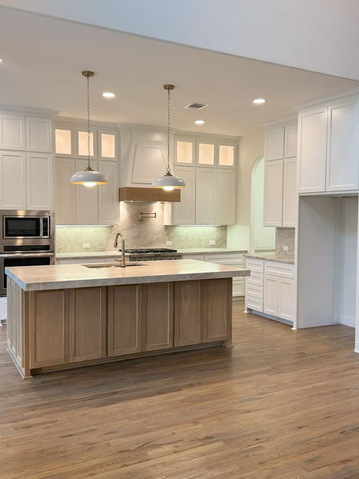 A kitchen under construction with white cabinets and a dishwasher.