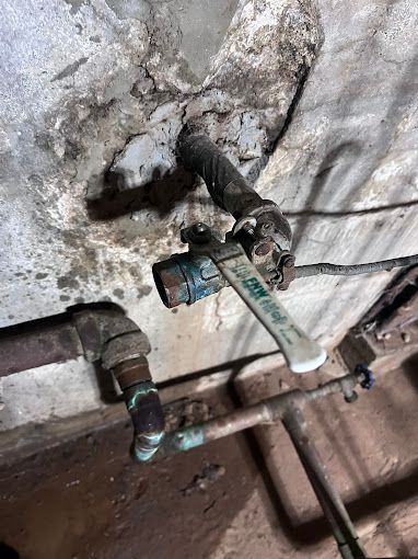 A close up of a water valve on a wall.