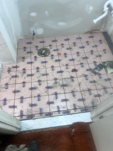 A bathroom floor with a lot of tiles on it.