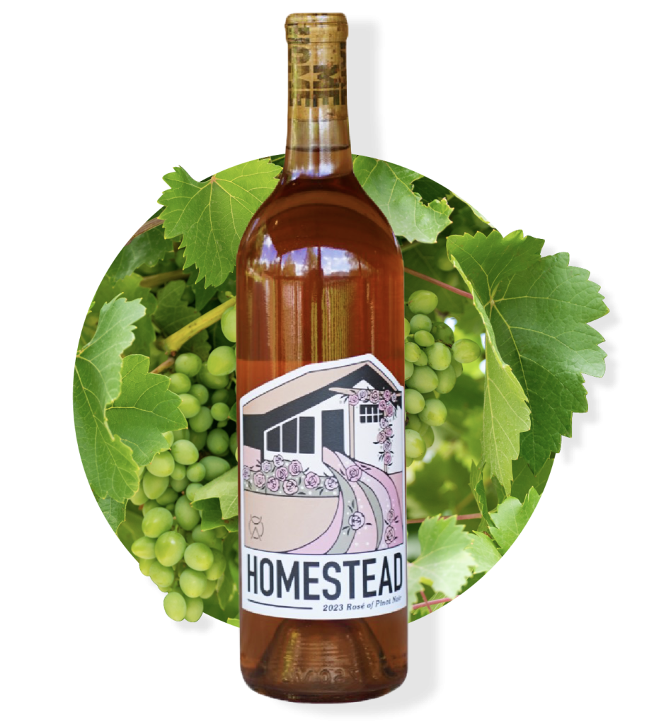 Rose-colored Homestead wine bottle with a label depicting a home, framed by grapes and leaves.