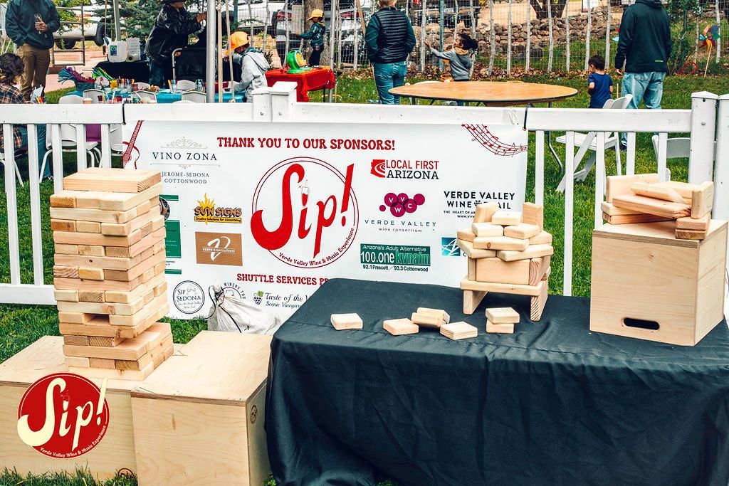 Giant Jenga and block structures on display at an outdoor event with a 