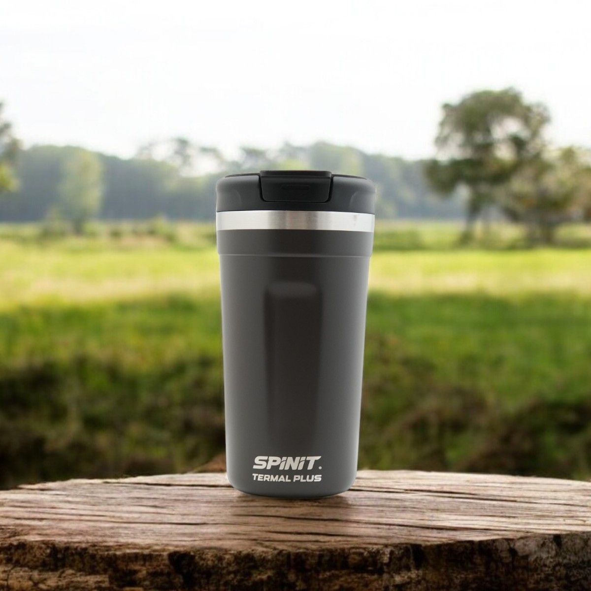 Taza de viaje SpinIt Termal Plus negra junto a su caja negra y naranja, ambas sobre un fondo blanco.