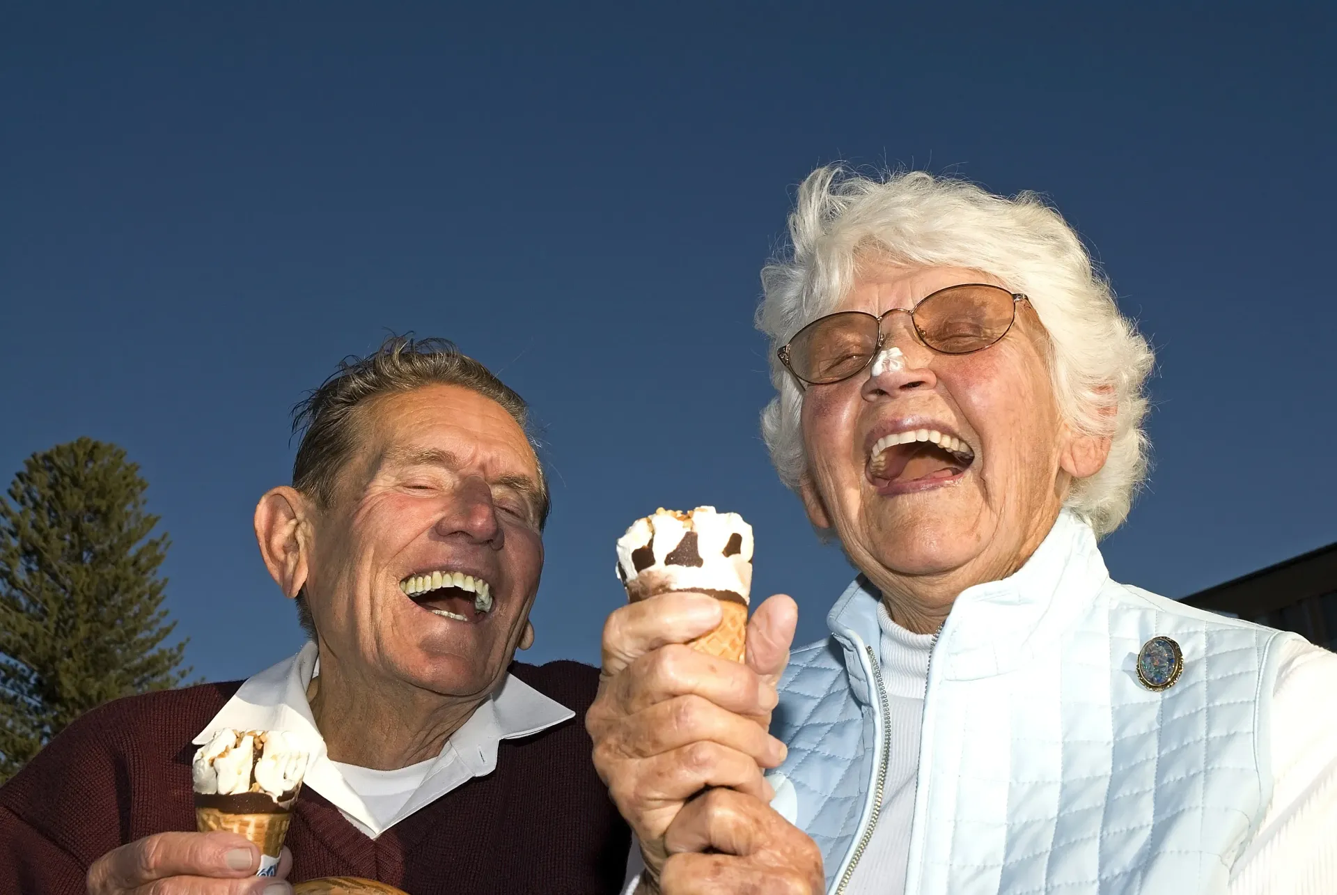 Two People Laughing and Holding ICE Cream Cones Outdoors Under a Clear Blue Sky — Smiles On Hobart in Hobart, TAS