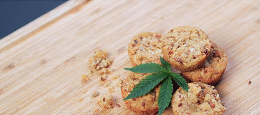 Cookies with cannabis leaf on a wooden board. Text: 