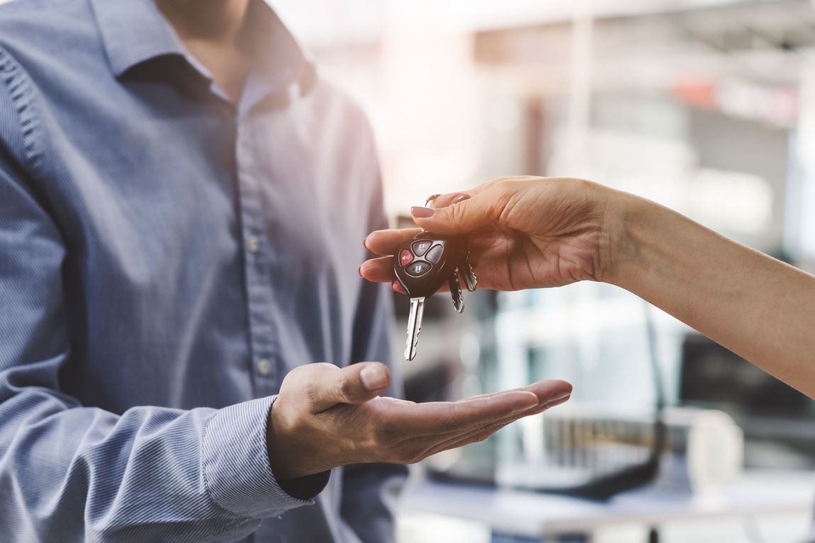Person receiving car keys from another person's hand. | Dave's Auto Care