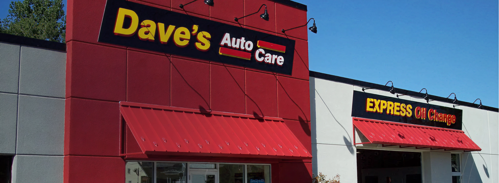 Exterior of Dave's Auto Care, red building with a sign and awning; Express Oil Shop next door. | Dave's Auto Care