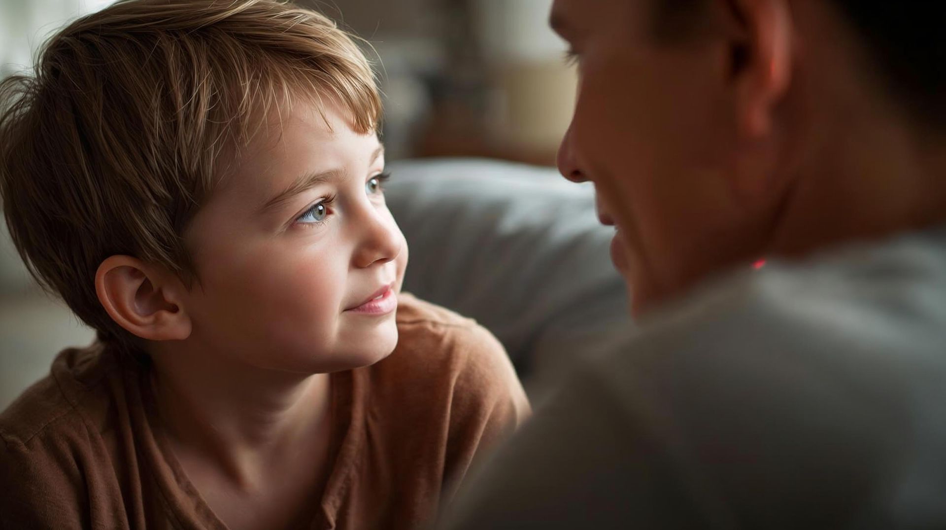 Young child gazing intently at a person, both appearing to be in an indoor setting.