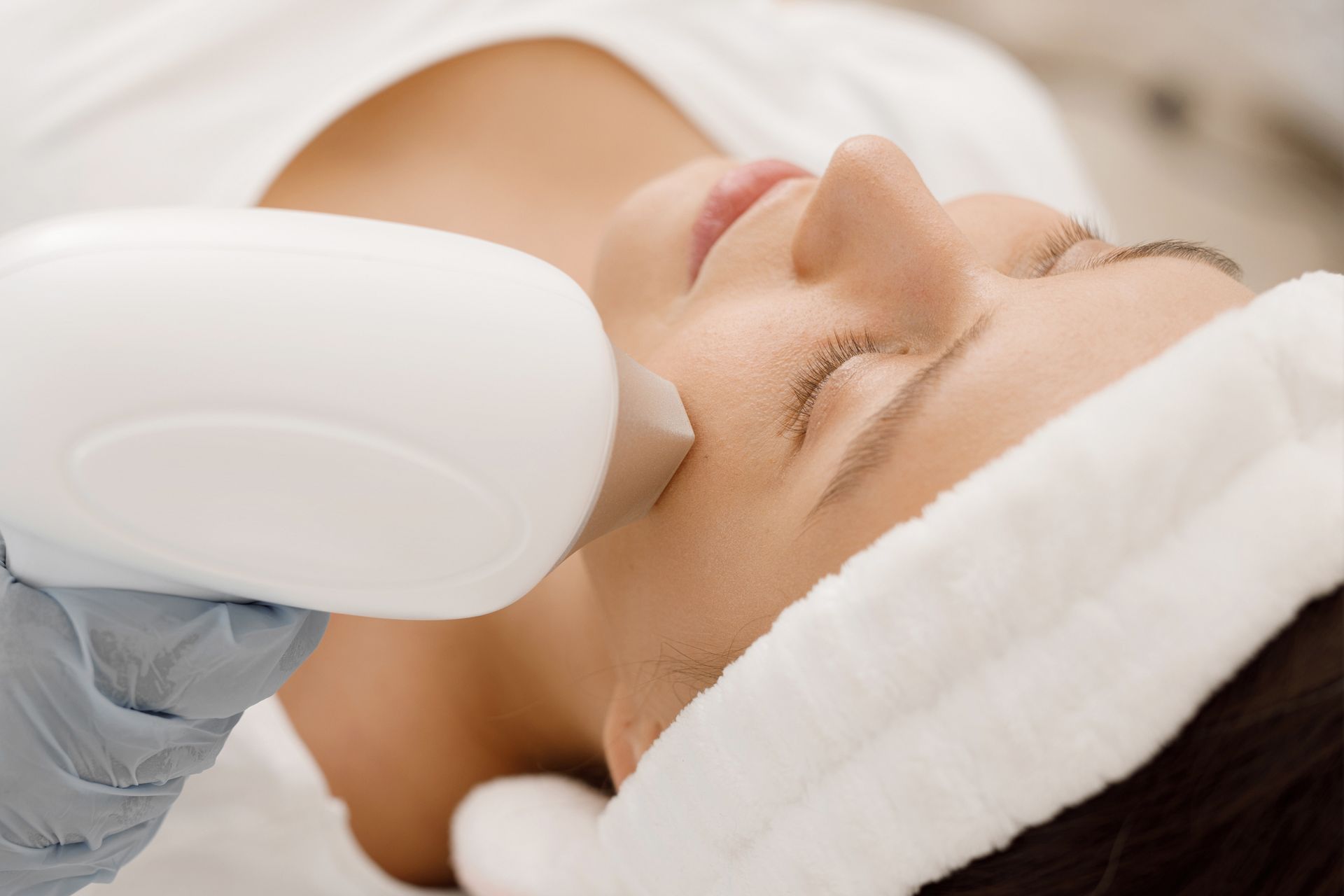 A woman is getting a laser treatment on her face.