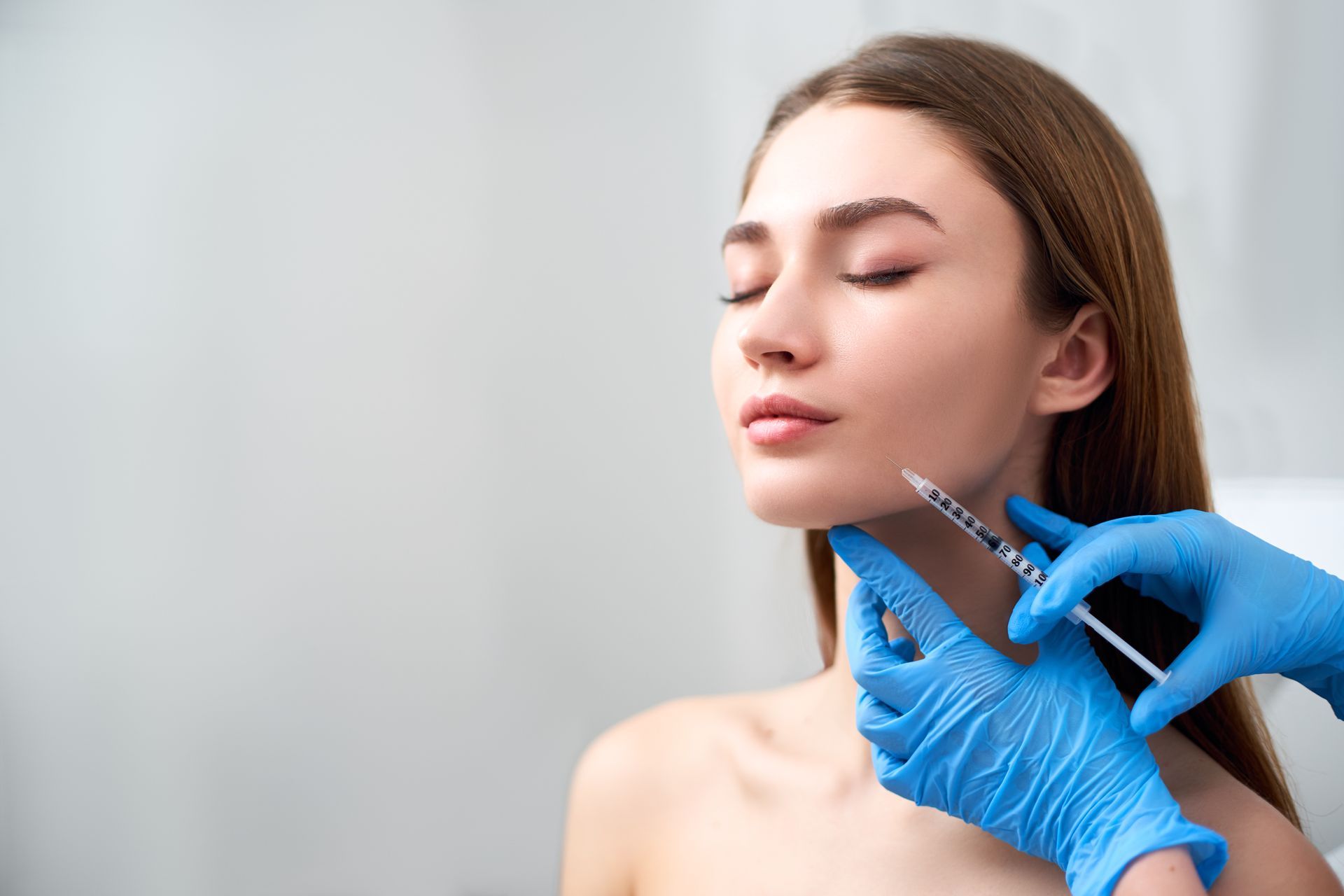 A woman is getting a botox injection in her face.