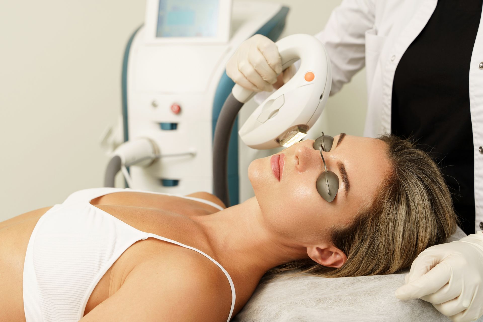 A woman is getting a laser treatment on her face.