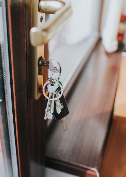 A bunch of keys are hanging from a door handle.