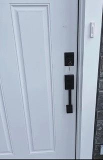 A bunch of keys are hanging from a door lock.