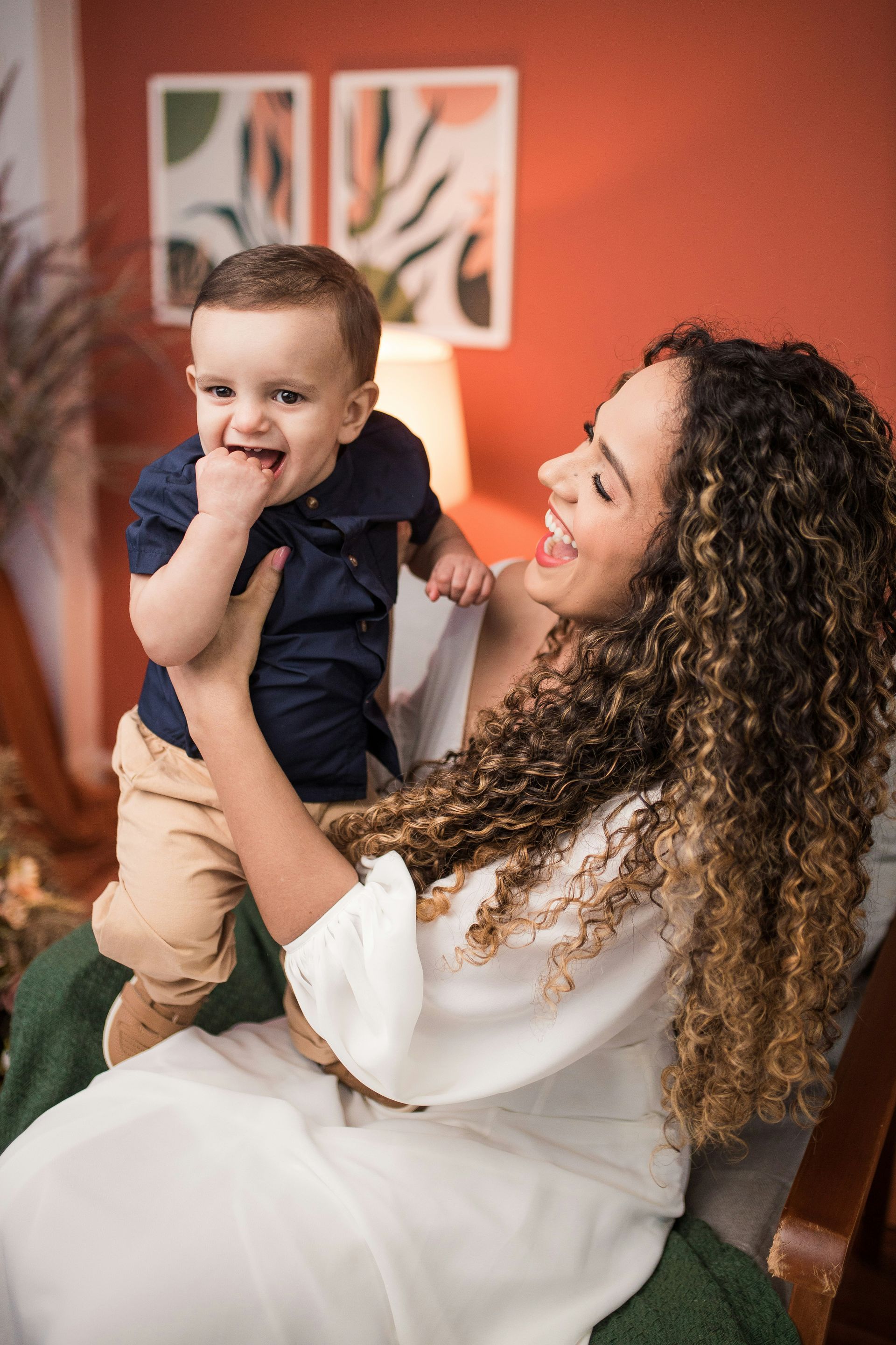 A woman is holding a baby in her arms while sitting on a couch.