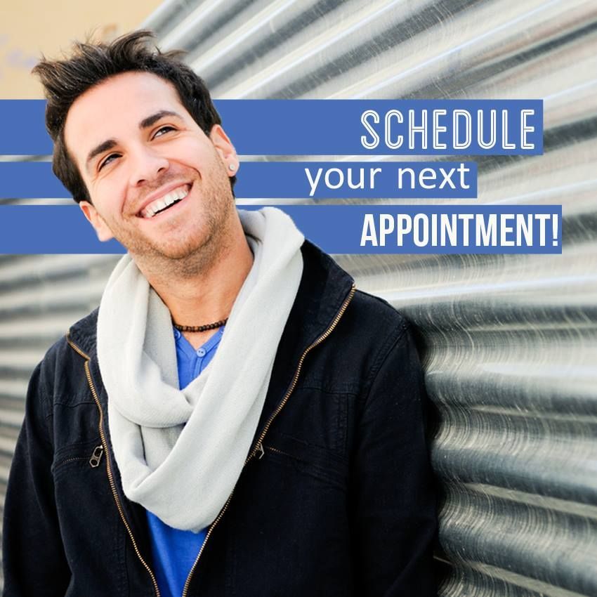 Smiling person leaning against metal wall; text says Schedule your next appointment!