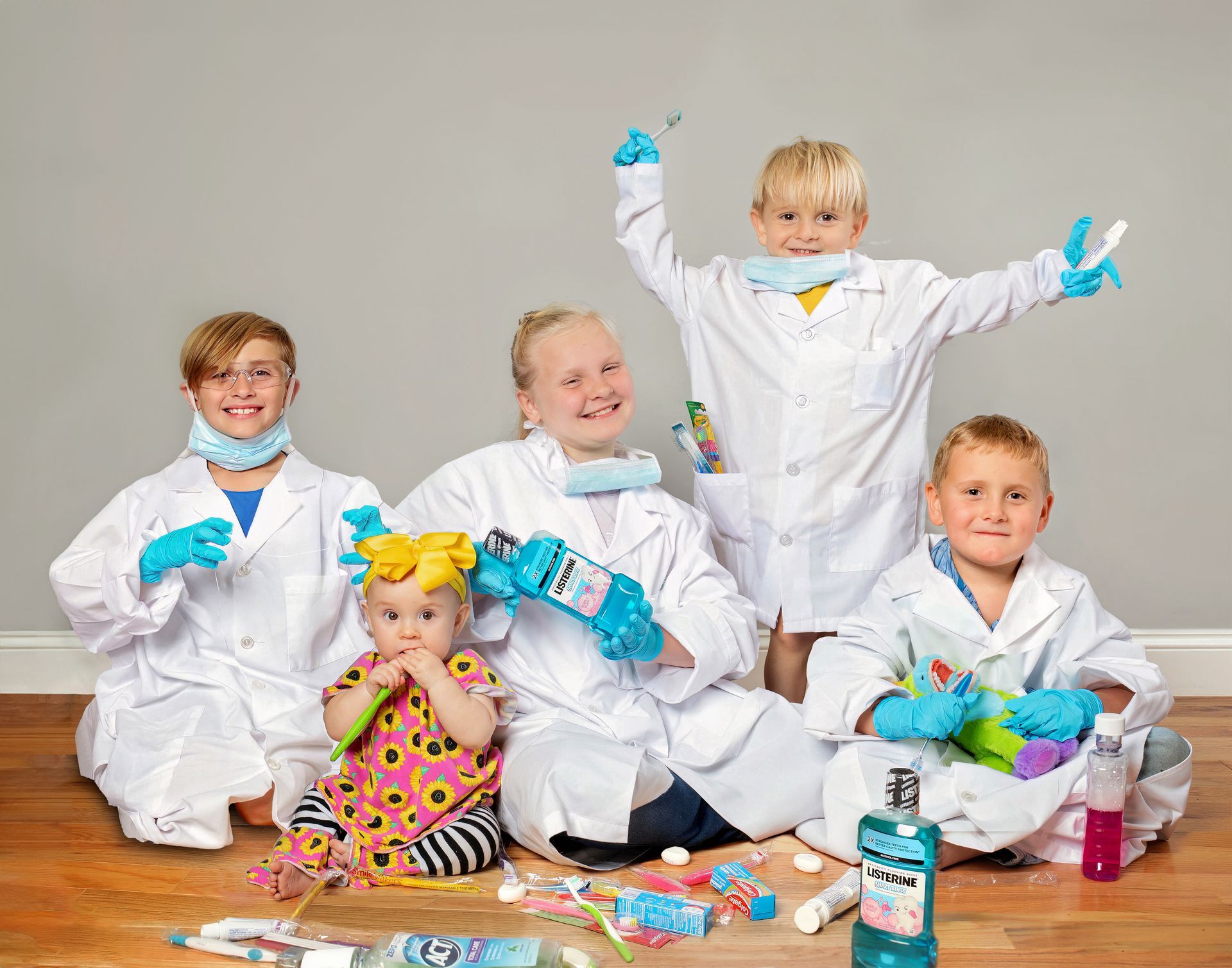 Group of people smiling, posing together, holding a pink ribbon balloon. They are standing indoors.